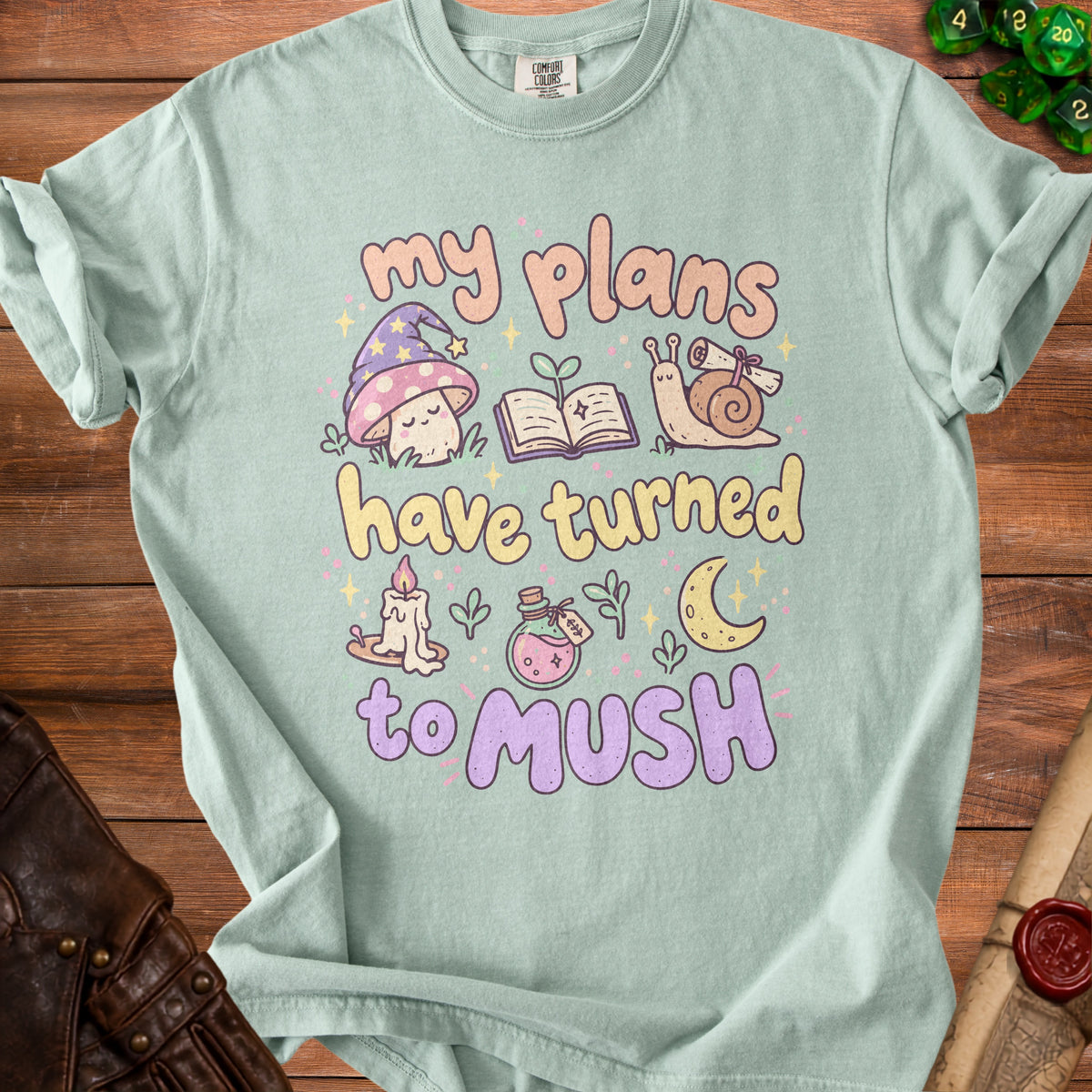 Mint t-shirt with "my plans have turned to mush" text and cute mushroom, snail, and book illustrations.