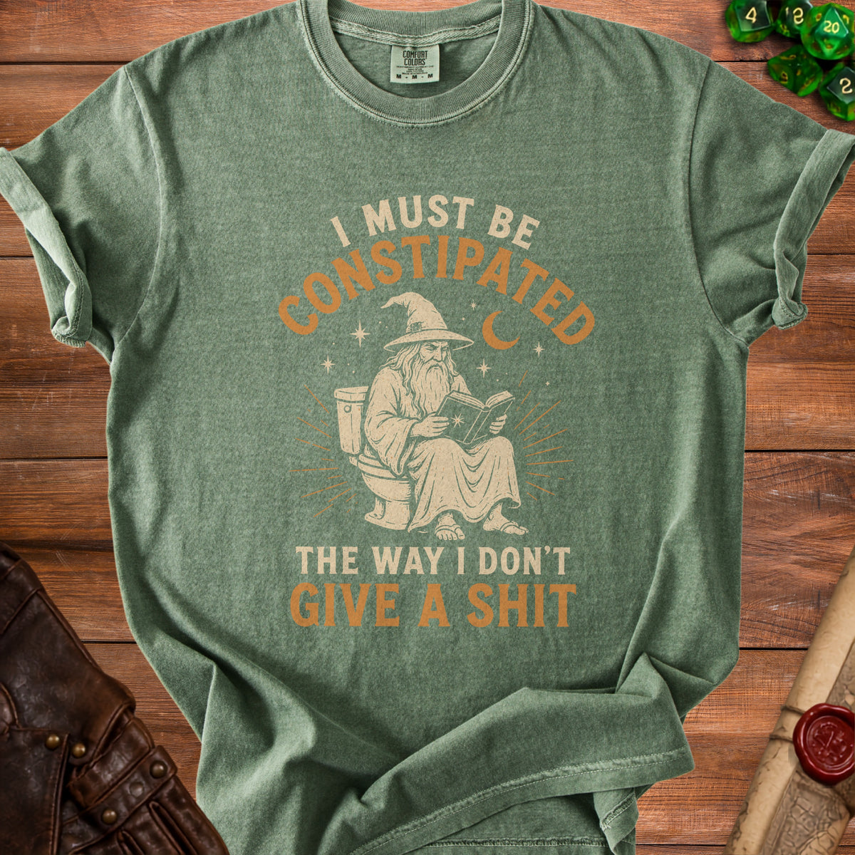 Green t-shirt with wizard on toilet reading and text "I must be constipated the way I don't give a shit".