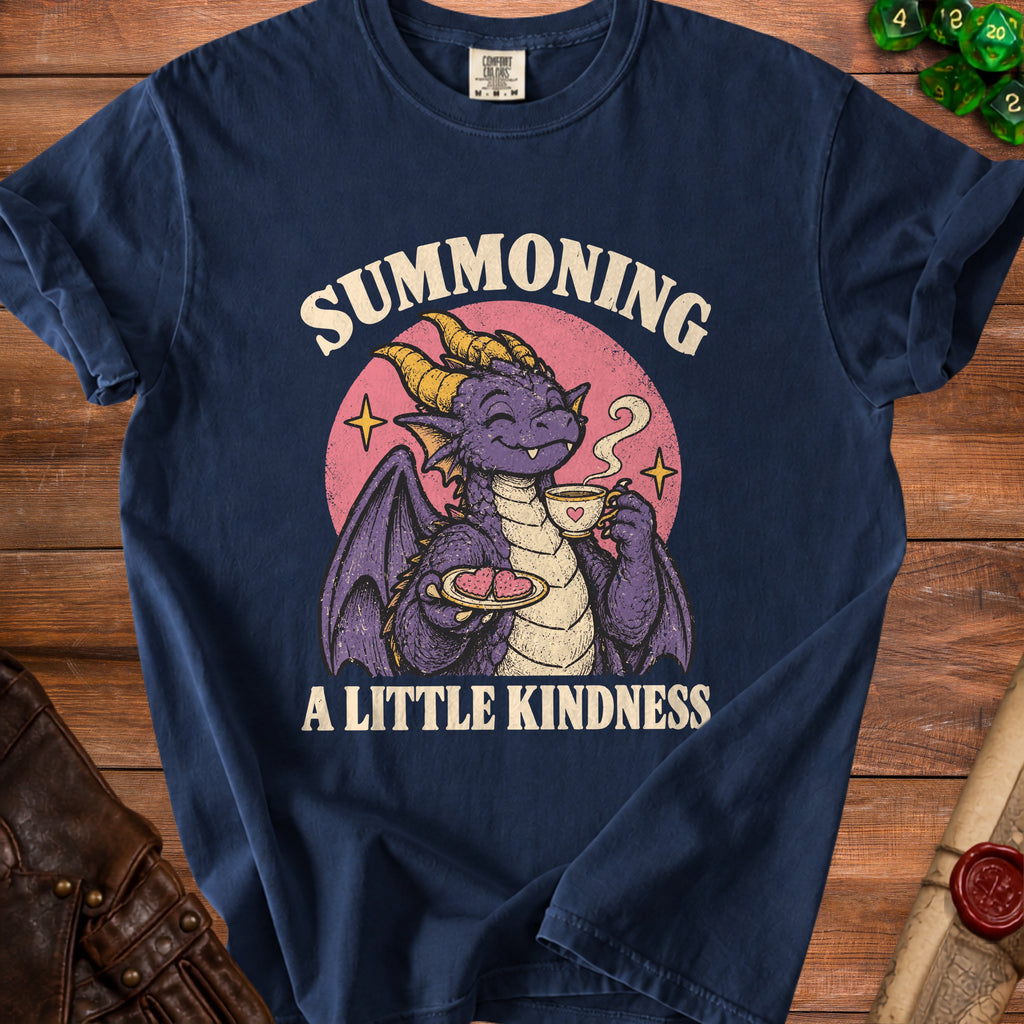 Dark blue t-shirt with a cartoon purple dragon drinking tea and holding cookies. Text reads "Summoning A Little Kindness."