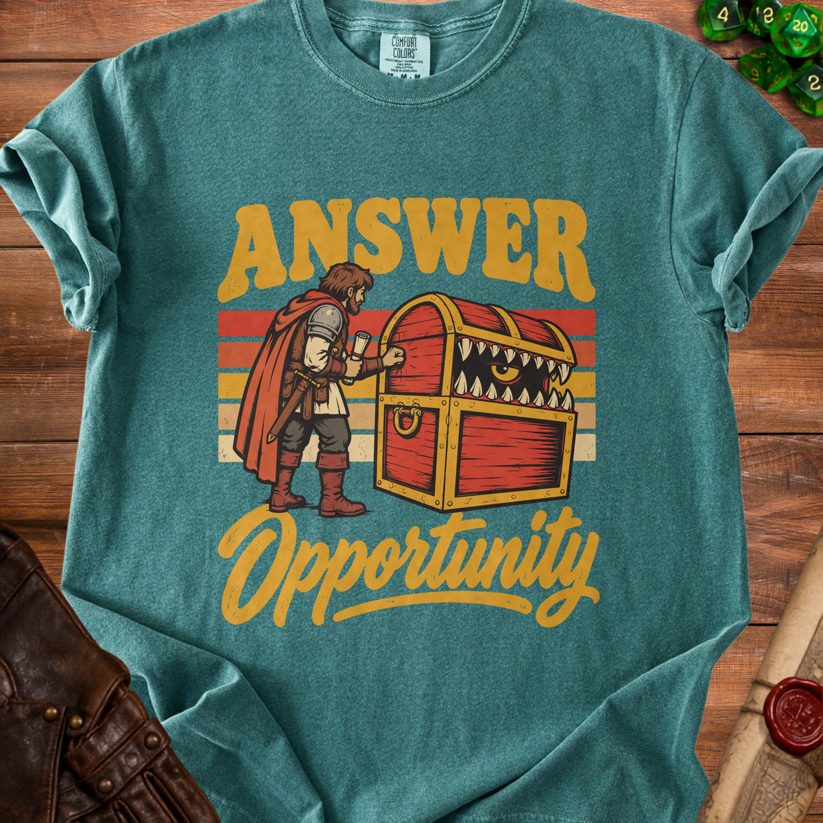 Teal shirt with a knight opening a treasure chest with a monster face.