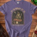 Frog wizard on mushroom holding coffee cup, text "IT IS WHAT IT IS" and "And it's pretty terrible".