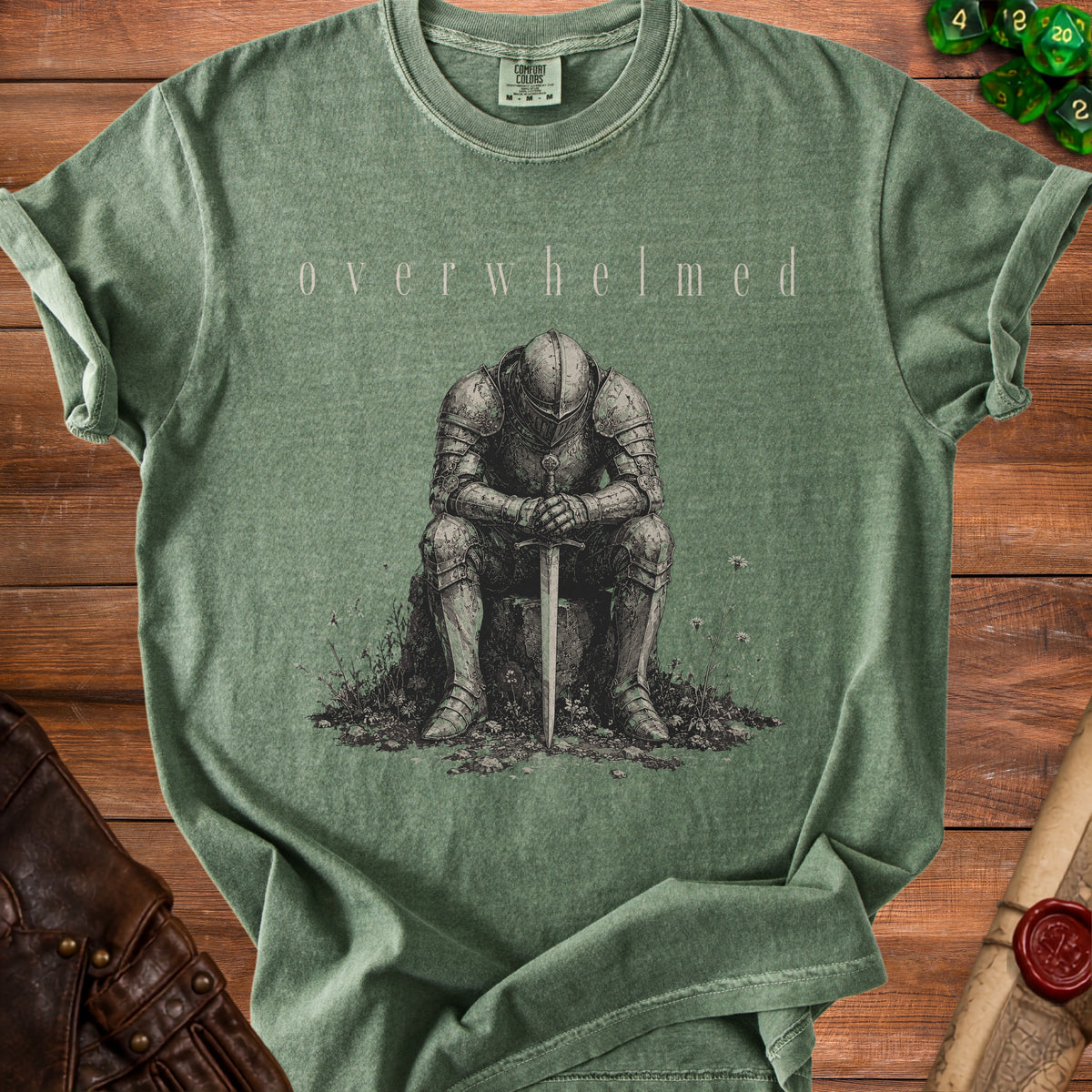 Green t-shirt with "overwhelmed" text and a drawing of a knight.