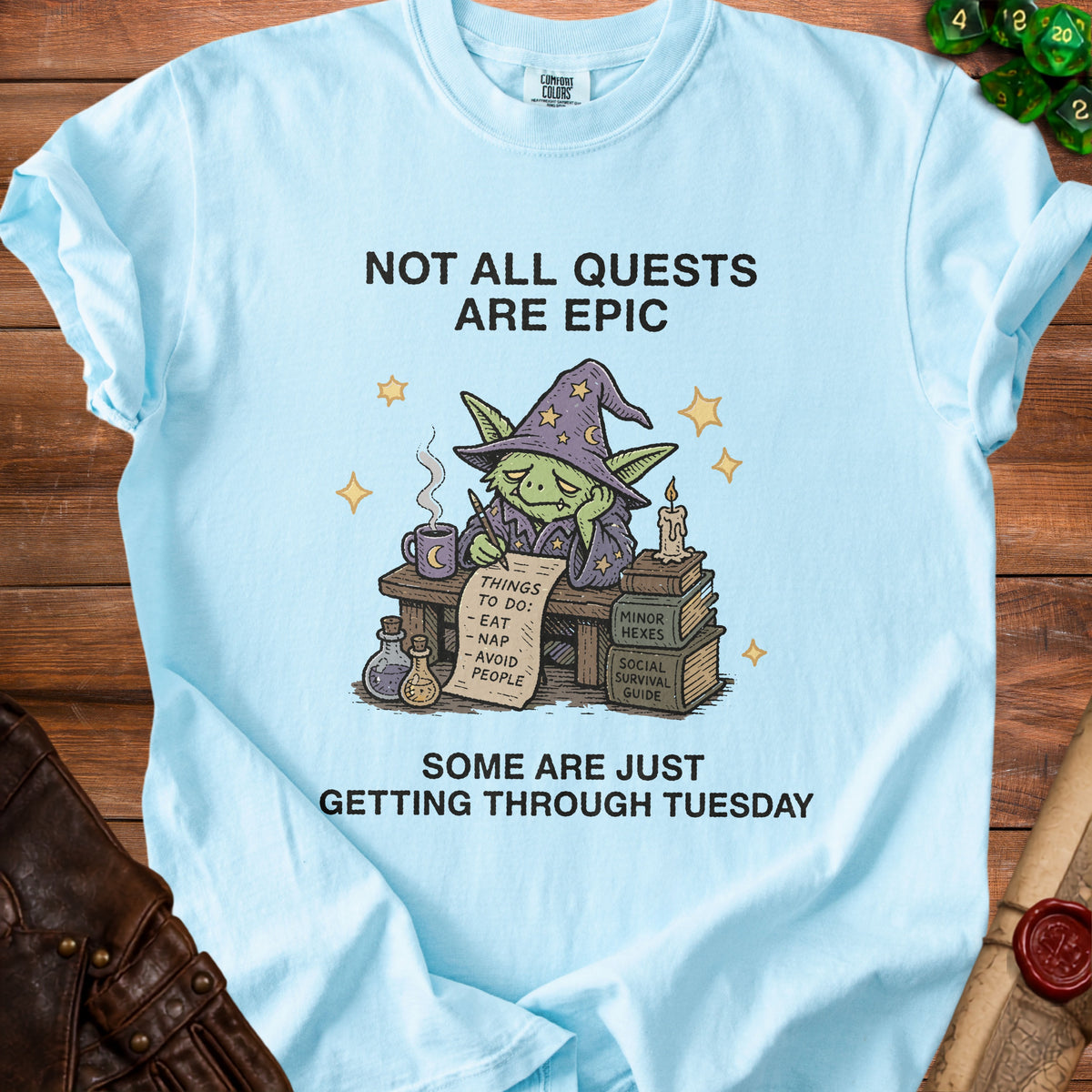 Light blue t-shirt with goblin wizard text "NOT ALL QUESTS ARE EPIC" and "SOME ARE JUST GETTING THROUGH TUESDAY".