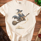 Cream t-shirt with vintage wizard flying on broomstick graphic.