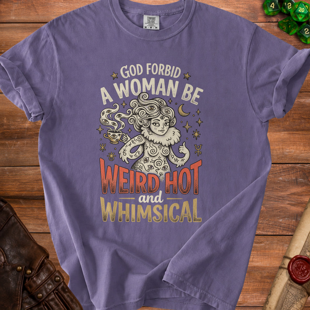 Purple t-shirt with "God forbid a woman be weird hot and whimsical" text and mystical graphic.
