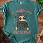 Plague doctor illustration with text "PLAGUED WITH PROBLEMS" on teal t-shirt.