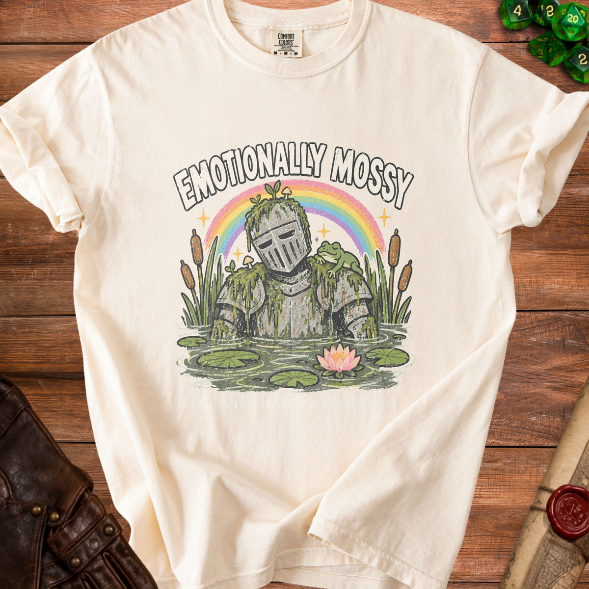 Cream t-shirt graphic of a mossy knight in water with text "Emotionally Mossy".