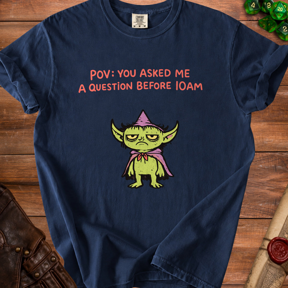 Navy t-shirt with grumpy goblin graphic and text "POV: YOU ASKED ME A QUESTION BEFORE 10AM".