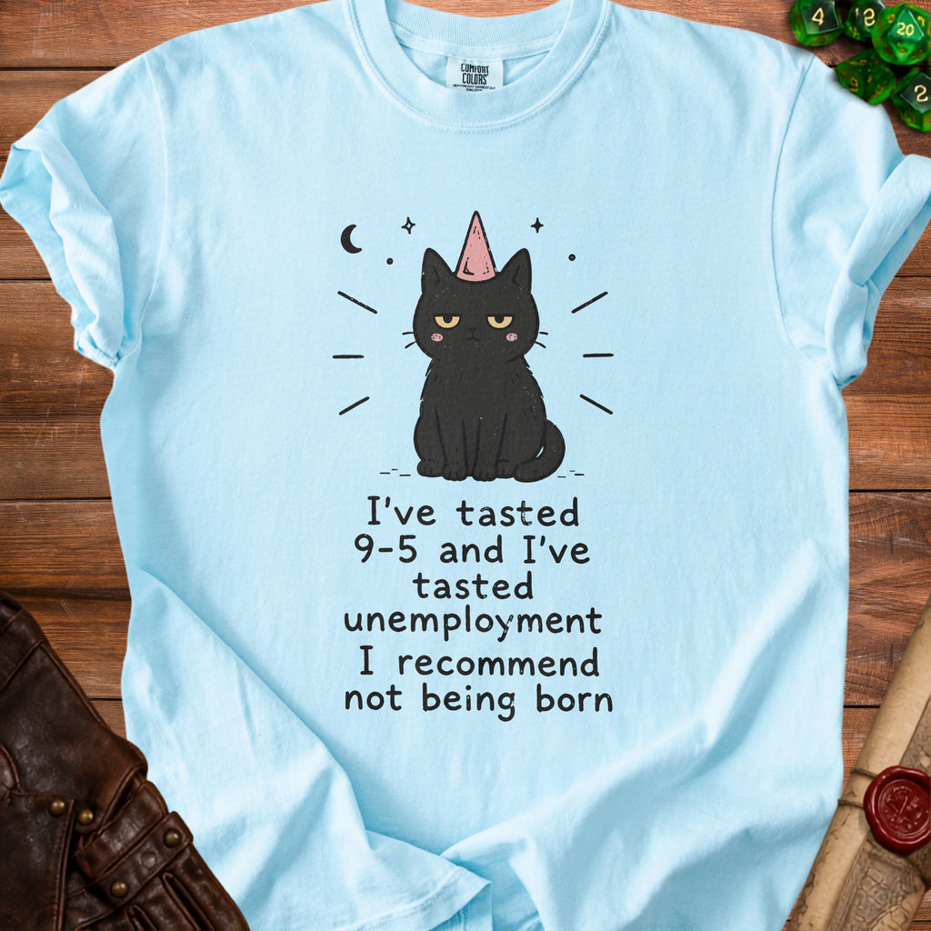 Light blue t-shirt with a graphic of a black cat wearing a party hat and the text "I've tasted 9-5 and I've tasted unemployment I recommend not being born."