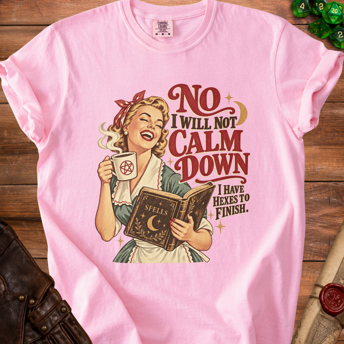 Pink t-shirt with retro witch illustration saying "No I will not calm down I have hexes to finish."