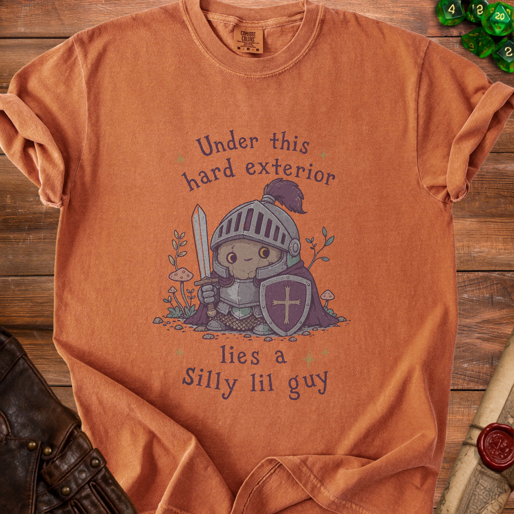Orange Comfort Colors shirt with knight graphic: "Under this hard exterior lies a Silly lil guy."