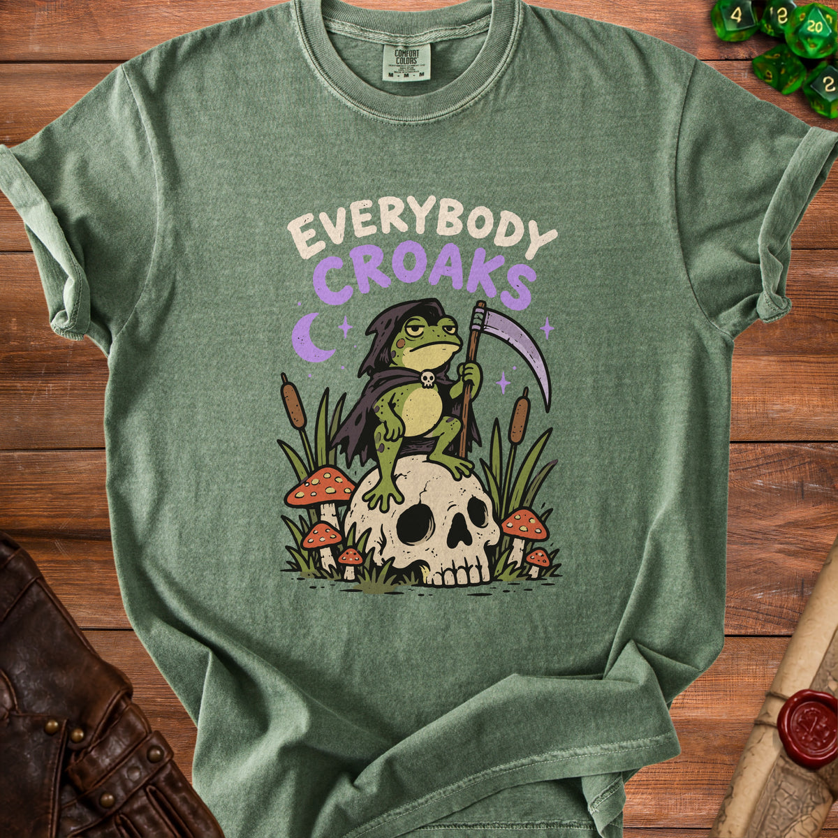 Green t-shirt with a grim reaper frog sitting on a skull graphic that reads "Everybody Croaks".