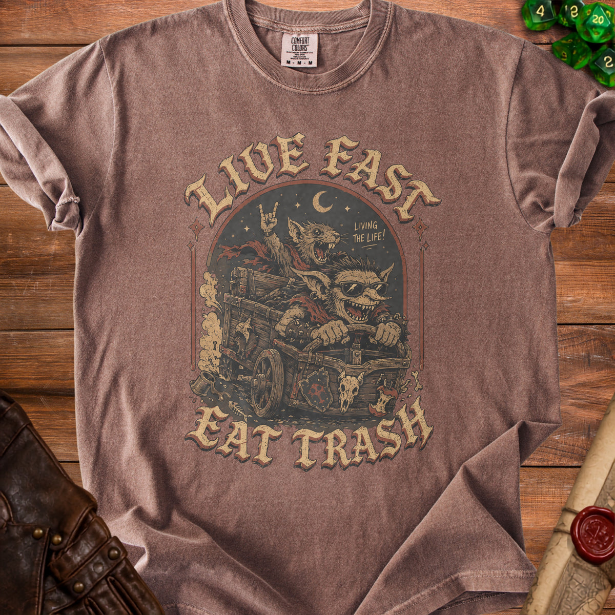 Brown t-shirt with graphic of cartoon rats in a cart with text "LIVE FAST EAT TRASH".
