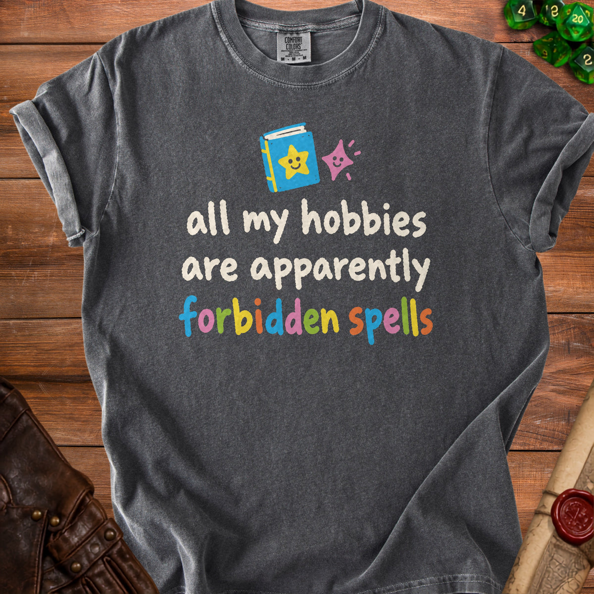 Dark gray t-shirt with "all my hobbies are apparently forbidden spells" text.