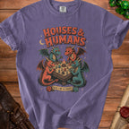 Purple t-shirt with a graphic of dragons playing a board game with dice and text "HOUSES & HUMANS" and "ROLL FOR RESIDENTS".