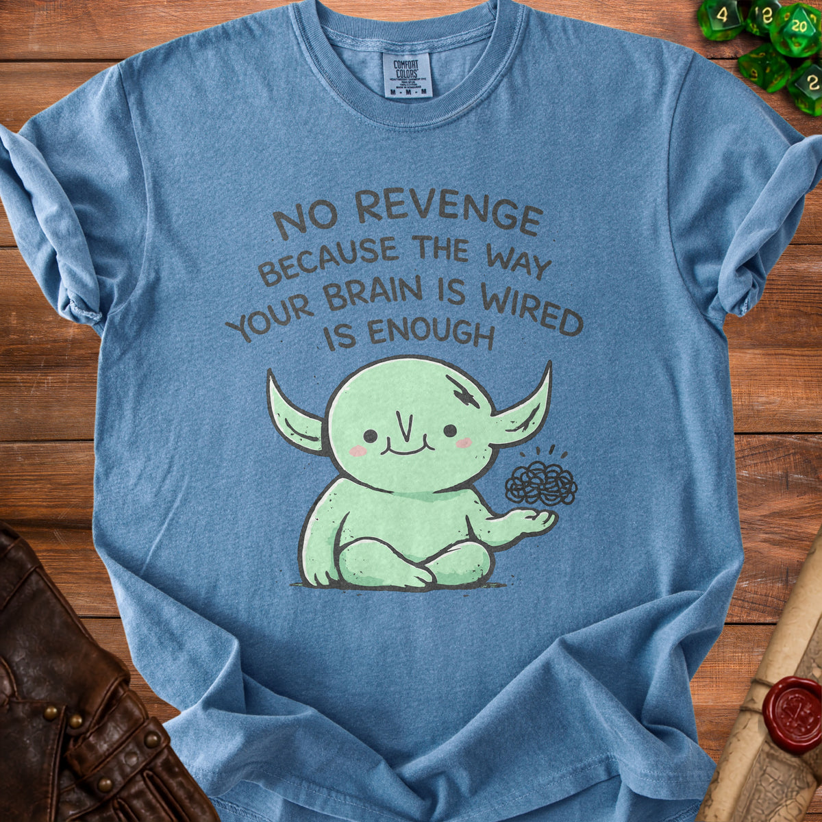 Blue t-shirt with green creature saying "No revenge because the way your brain is wired is enough".