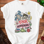 White t-shirt with "I Cast Minor Inconvenience" graphic featuring a wizard, cat, and dice.