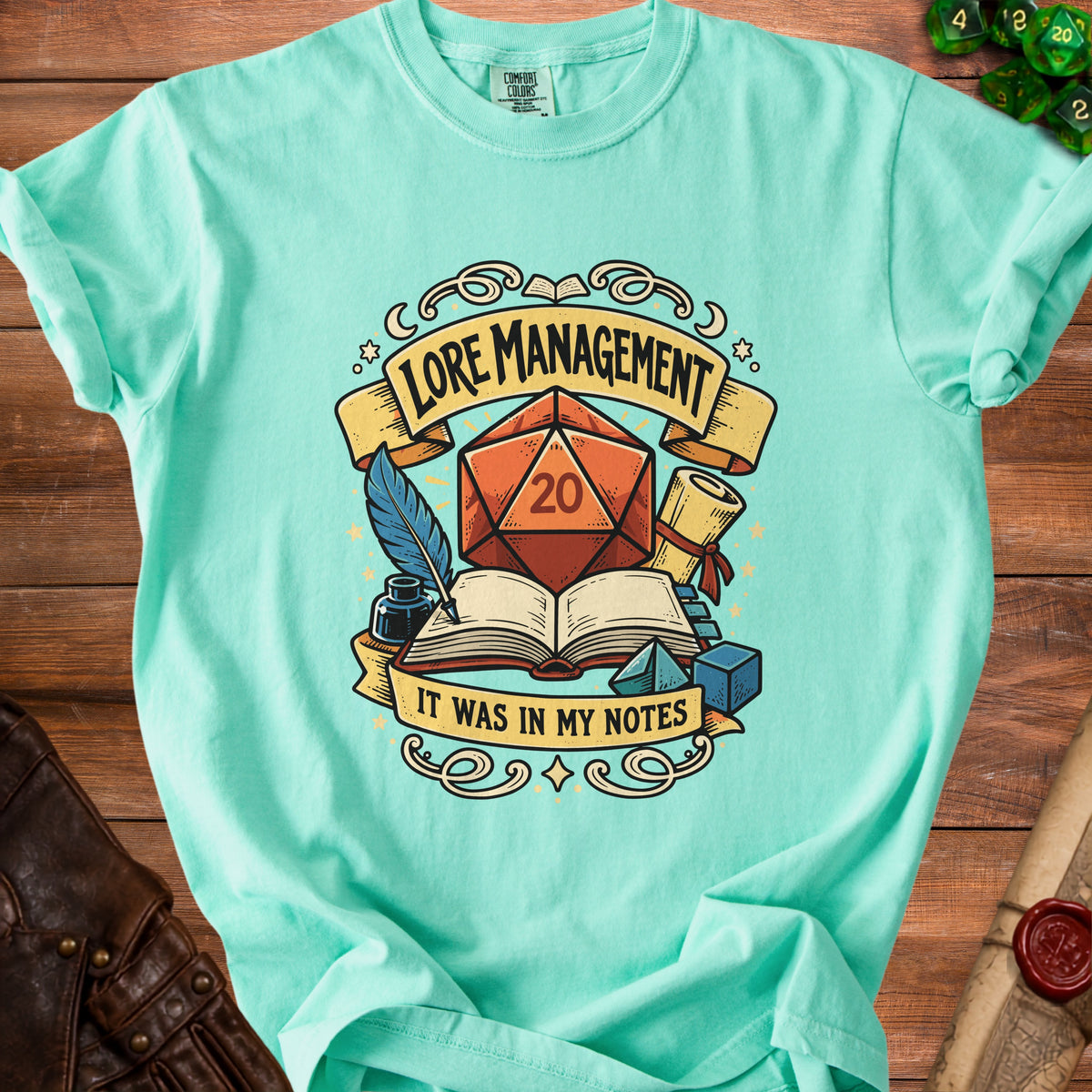 Aqua t-shirt with "Lore Management It Was In My Notes" text and D20 graphic.