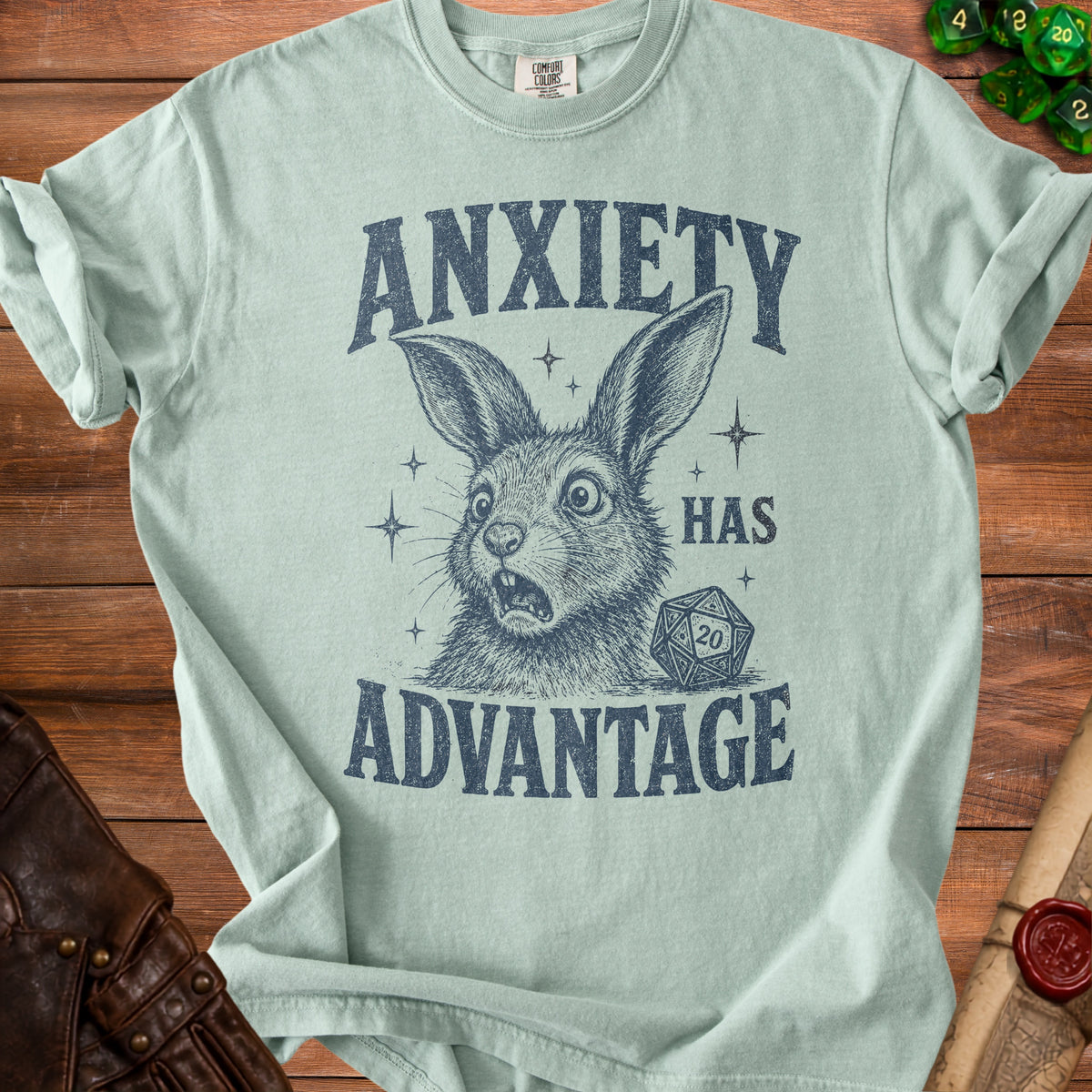 Light blue t-shirt with distressed graphic of a shocked bunny, dice, and text "Anxiety Has Advantage."