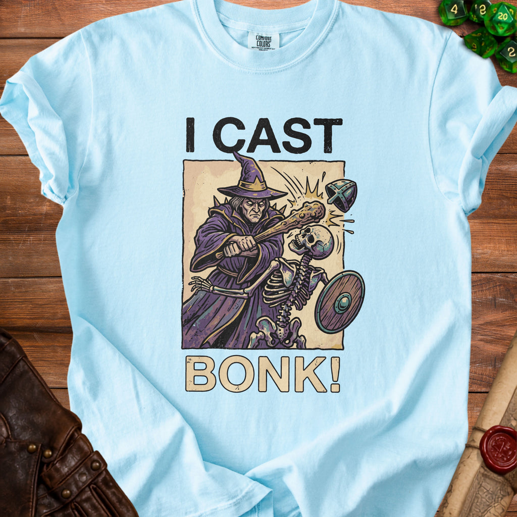 Light blue t-shirt with "I CAST BONK!" graphic of a wizard attacking a skeleton.