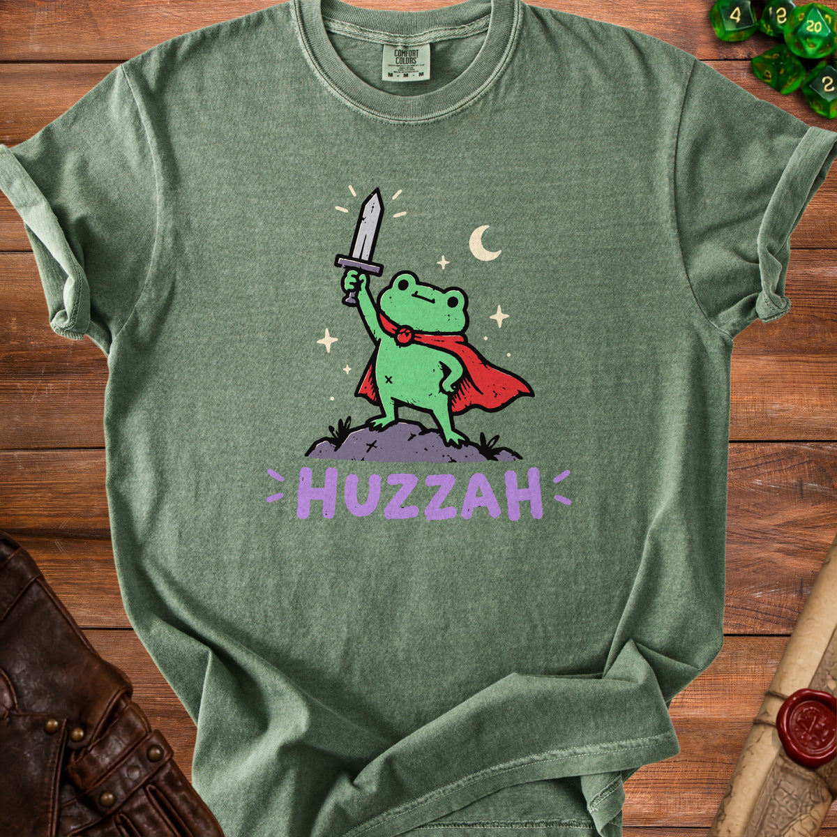 Green t-shirt with a cartoon frog wearing a cape and holding a sword with text "HUZZAH".