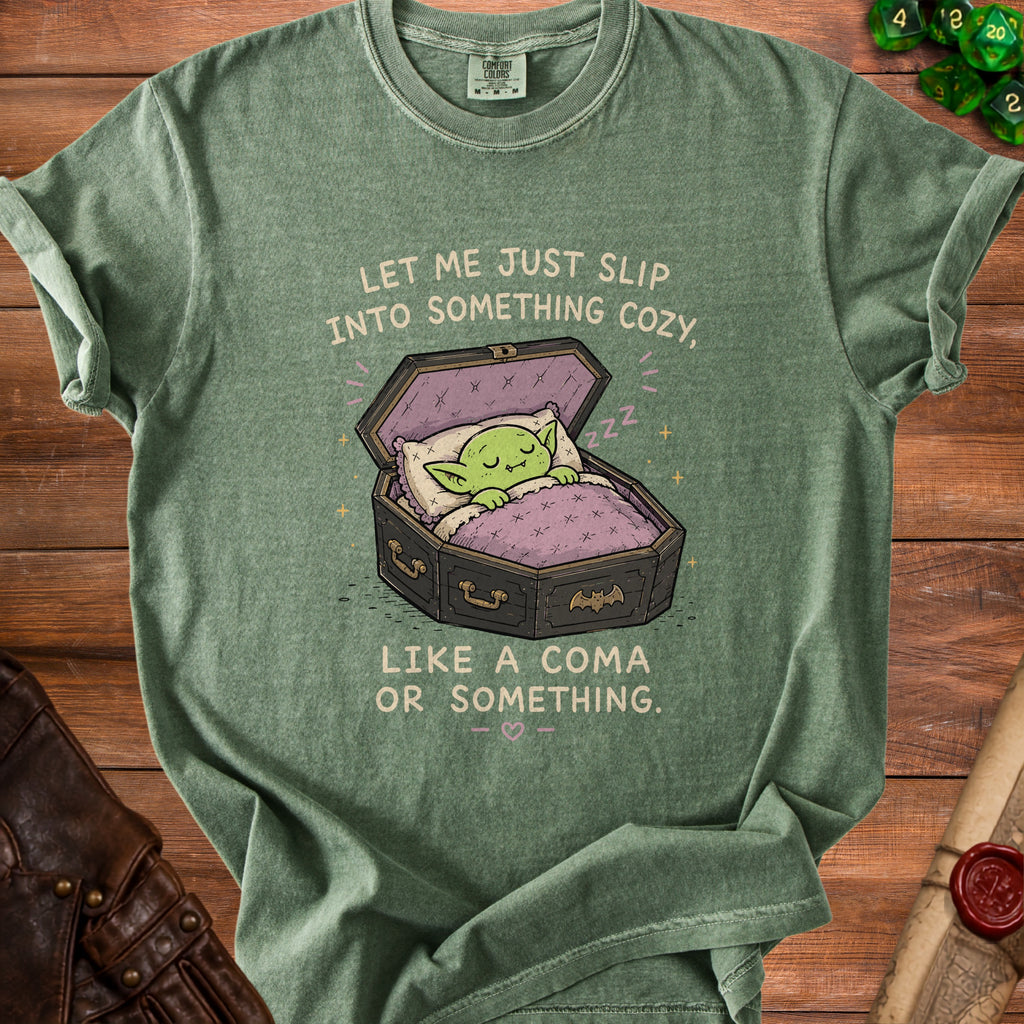 Green t-shirt with a cartoon goblin sleeping in a coffin, text reads "Let me just slip into something cozy, like a coma or something."