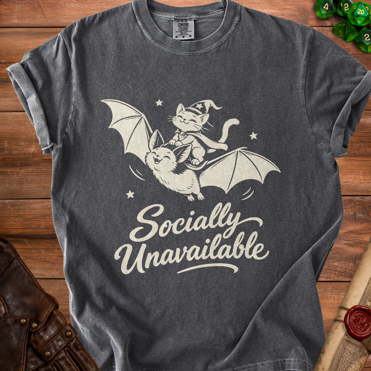 Dark gray t-shirt with a graphic of a cat in a wizard hat riding a bat, saying "Socially Unavailable."