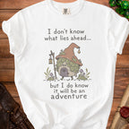 White t-shirt with mushroom gnome and text "I don't know what lies ahead... but I do know it will be an adventure".