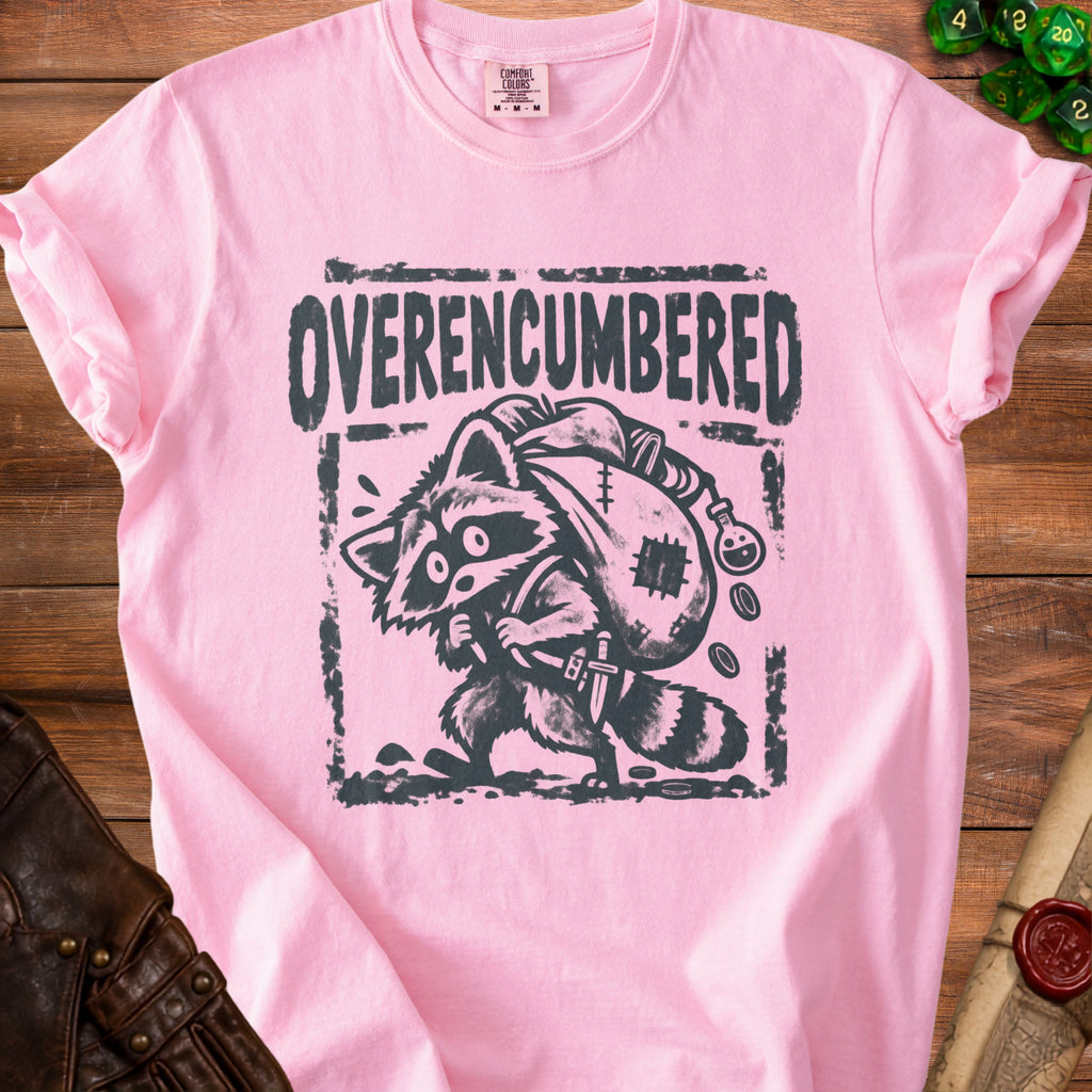 Pink t-shirt with "Overencumbered" text and a raccoon carrying a sack and sword.