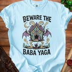 Light blue t-shirt graphic featuring "Beware the Baba Yaga" text and illustration.