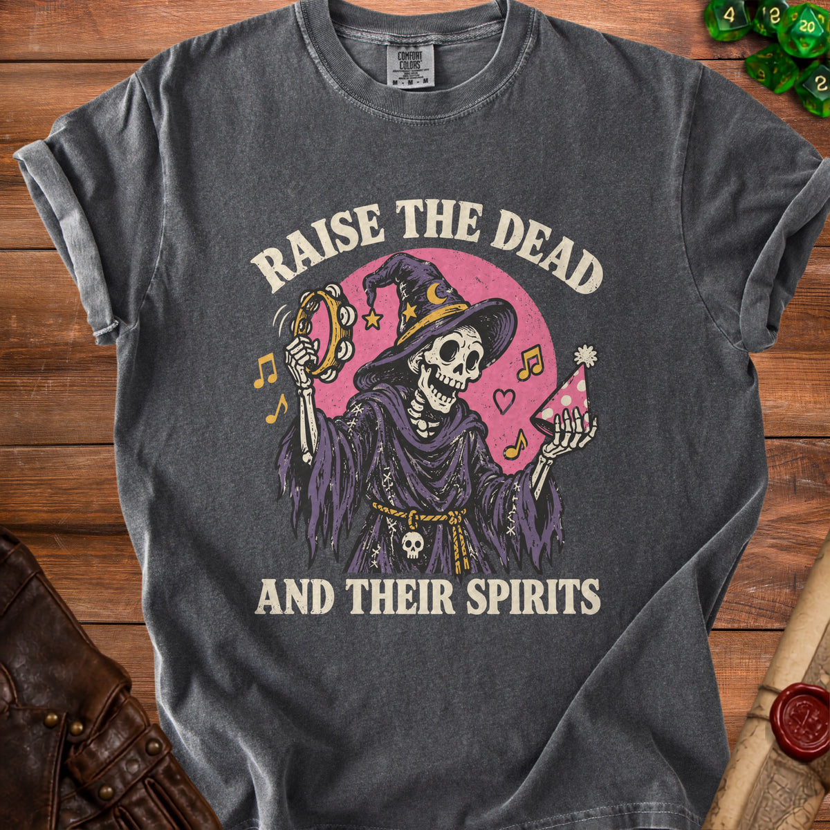 Skeleton wearing witch hat playing tambourine and holding party hat, text "RAISE THE DEAD AND THEIR SPIRITS".