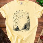 Witch silhouette with a mug, staff, and pumpkin, surrounded by bats and trees near a cave.