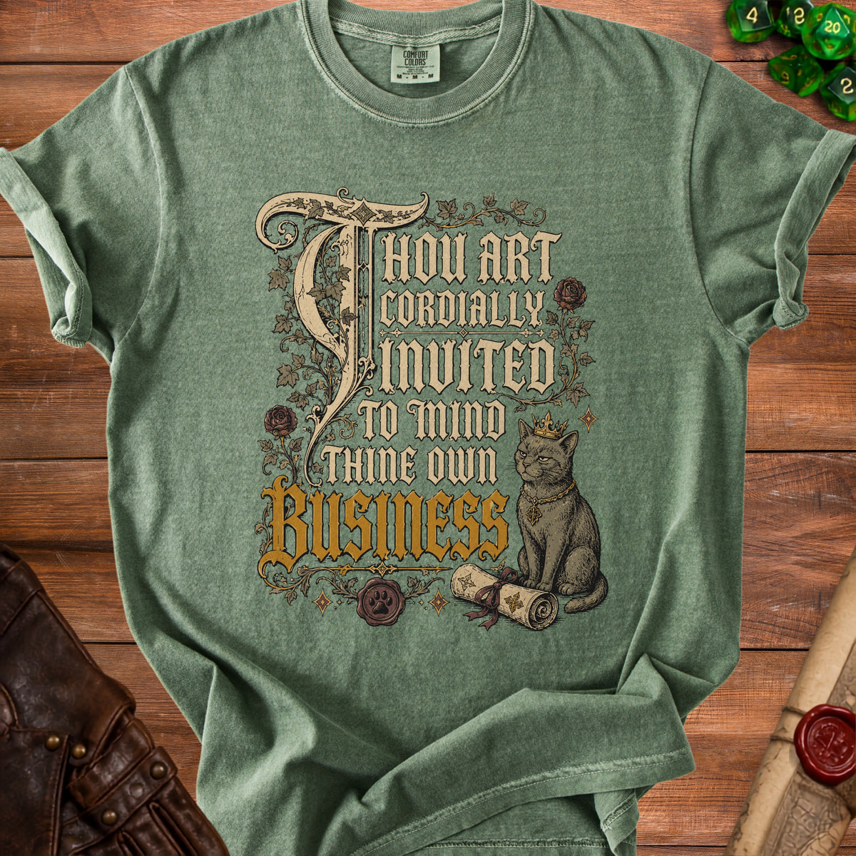 Green t-shirt with ornate text and a crowned cat reading a scroll.