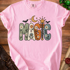 Pink t-shirt with "MAGIC" text in groovy font with floral and celestial designs.
