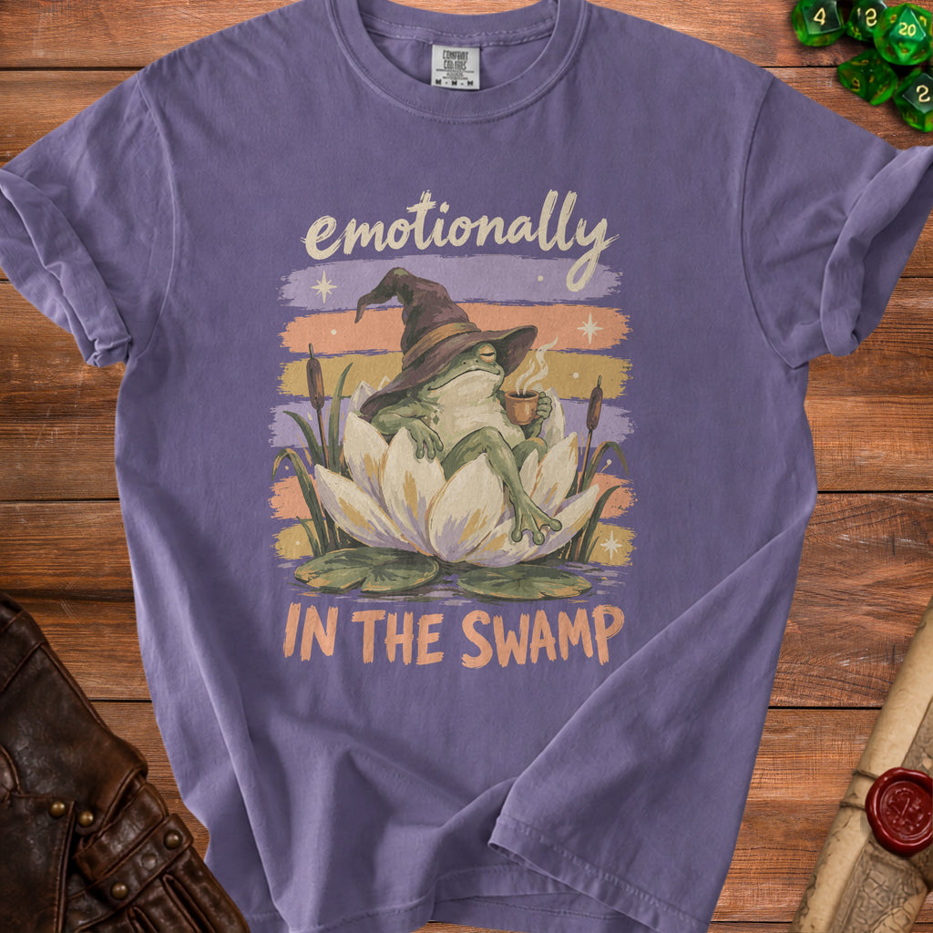 Frog in witch hat drinks coffee on lily pad with text "emotionally IN THE SWAMP".