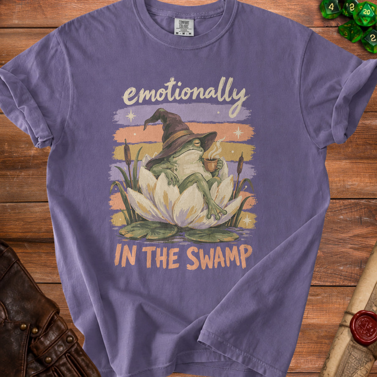 Frog in witch hat drinks coffee on lily pad with text "emotionally IN THE SWAMP".
