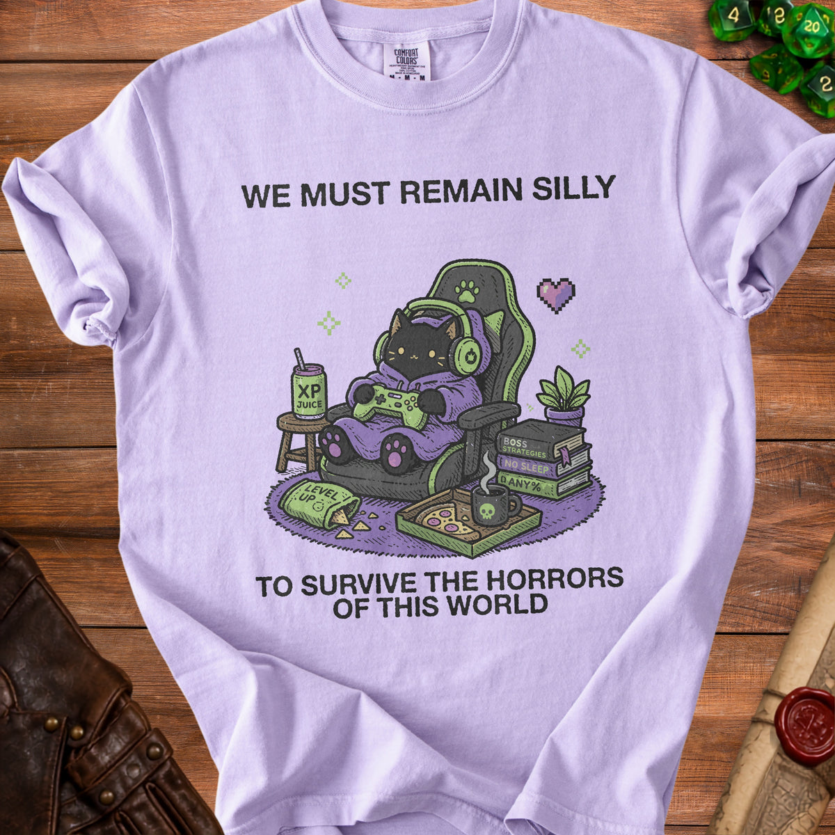 Purple t-shirt with black cat gamer, XP juice, pizza, and text "We Must Remain Silly To Survive the Horrors of This World".
