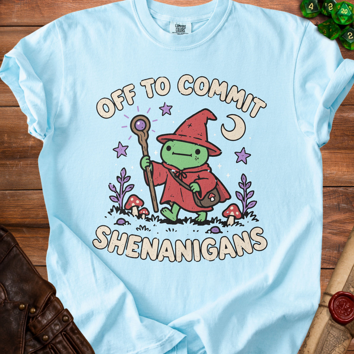 Light blue t-shirt with cartoon frog wizard saying "Off to Commit Shenanigans".