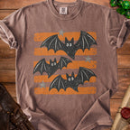 Brown t-shirt with distressed graphic of three bats and orange stripes.