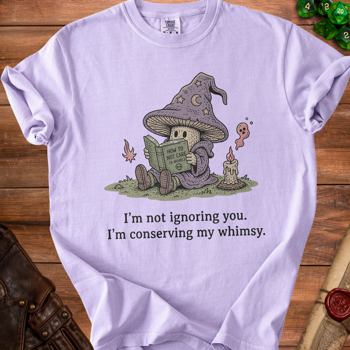 Lavender t-shirt with wizard mushroom reading "How to Not Care" and text "I'm not ignoring you. I'm conserving my whimsy."