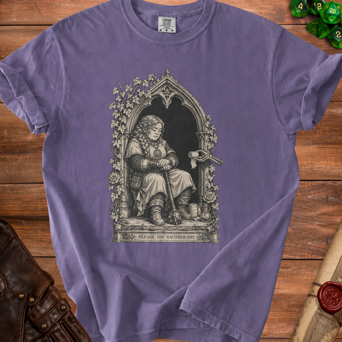 Purple t-shirt with black and white art of a seated warrior woman and text "PLEASE DIE ANOTHER DAY."