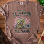 T-shirt graphic: goblin eating cookies by a laptop, "Website: We Use Cookies. Me: Same."