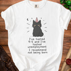 White t-shirt with a disgruntled black cat wearing a pink party hat and text about life.
