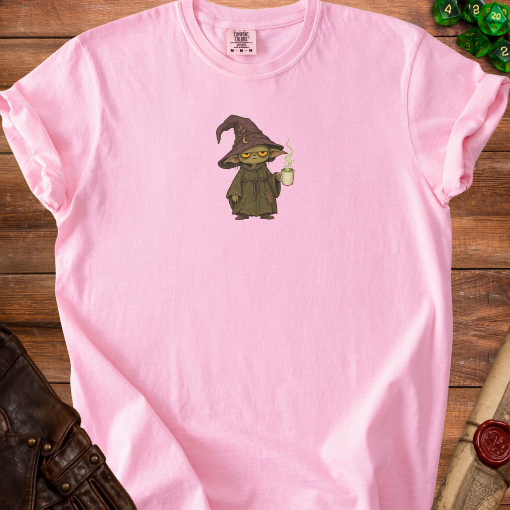 Pink t-shirt with a green wizard character holding a steaming mug.