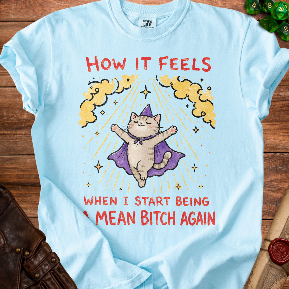 Light blue t-shirt with a cat in a wizard hat and cape, saying "How it feels when I start being a mean bitch again".