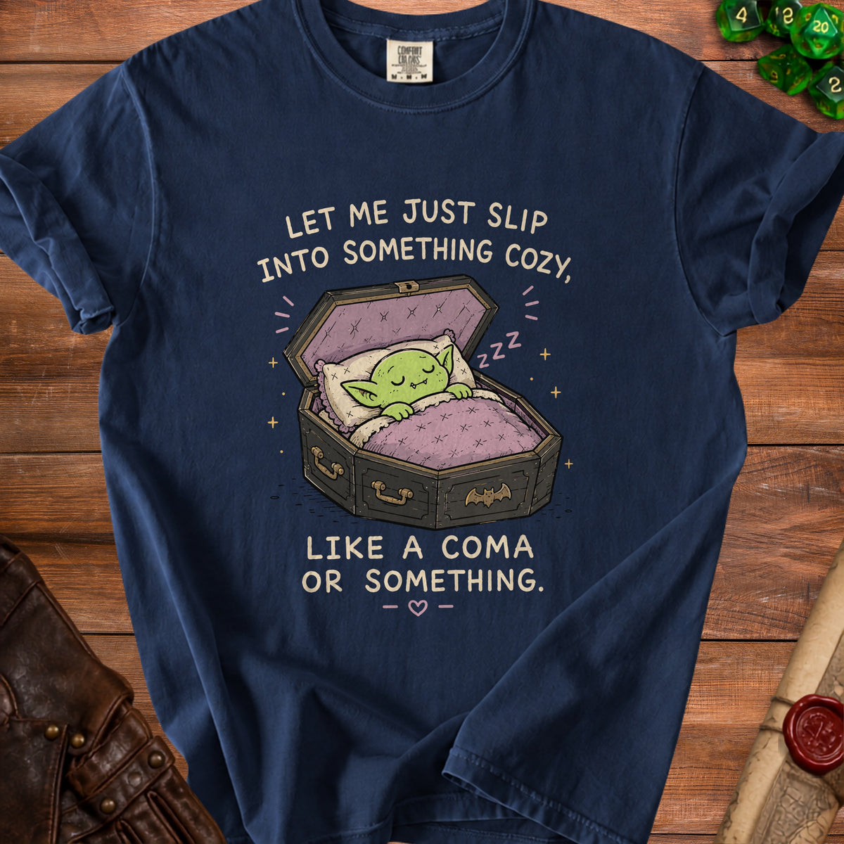 Dark blue t-shirt graphic of a green creature sleeping in a coffin with text.