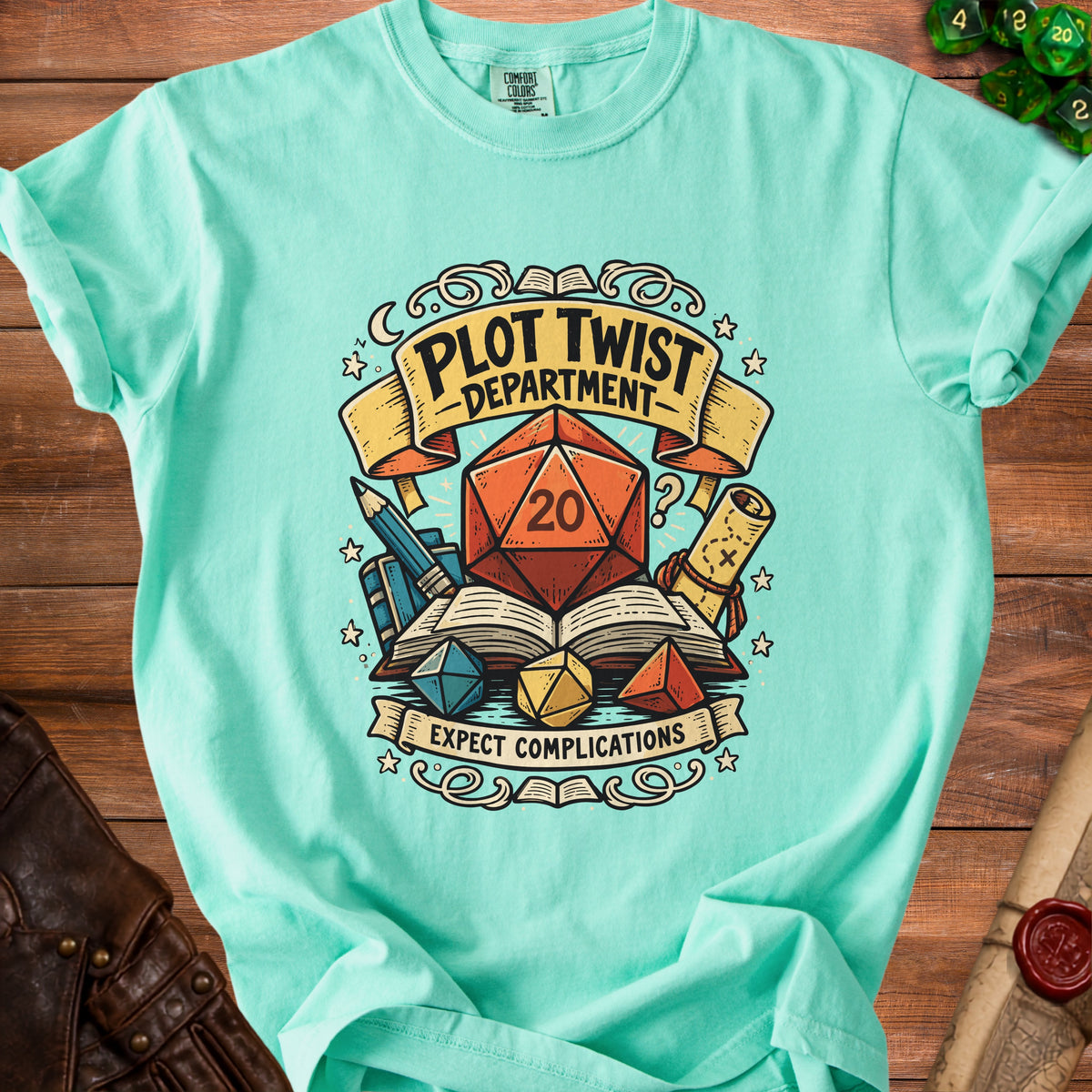 Mint green t-shirt with "Plot Twist Department" and "Expect Complications" graphic.