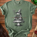 Green t-shirt with a frog wizard on a mushroom and the text "I FOLLOWED THE VIBES".