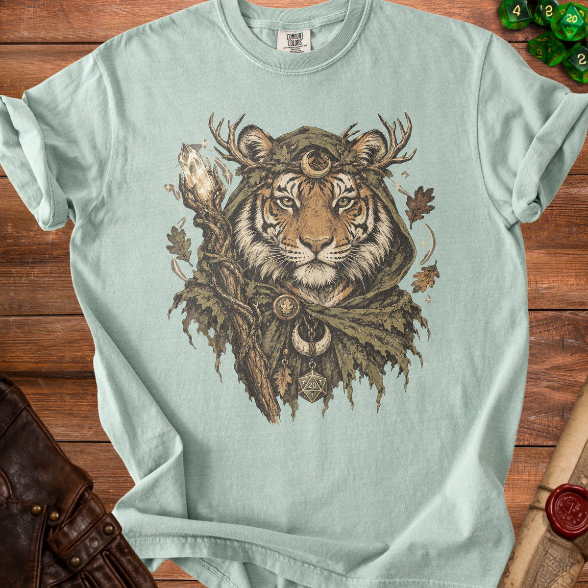 Tiger shaman wearing a hood and antlers, holding a crystal staff, on a light green t-shirt.