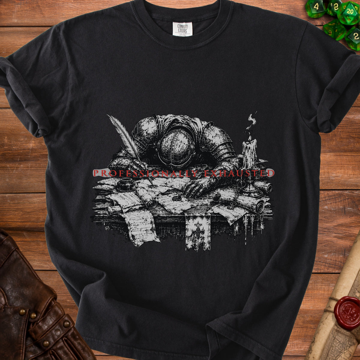 Black t-shirt with a drawing of a knight resting on papers, with text "PROFESSIONALLY EXHAUSTED".